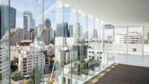 Vue sur la paysage urbain moderne du quartier de la defense depuis l'un des étages du bâtiment avec des murs en verre, surplombant de hauts gratte-ciel et des bâtiments urbains sous un ciel bleu clair.